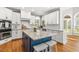 Bright kitchen featuring stainless steel appliances, white cabinets, a blue island and granite countertops at 206 W Stoneybrook Ct, Benson, NC 27504