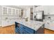 Bright kitchen featuring stainless steel appliances, white cabinets, a blue island and granite countertops at 206 W Stoneybrook Ct, Benson, NC 27504