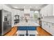 Bright kitchen featuring stainless steel appliances, white cabinets, a blue island and granite countertops at 206 W Stoneybrook Ct, Benson, NC 27504