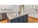 Bright kitchen featuring stainless steel appliances, white cabinets, a blue island and granite countertops at 206 W Stoneybrook Ct, Benson, NC 27504