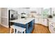 Bright kitchen featuring stainless steel appliances, white cabinets, a blue island and granite countertops at 206 W Stoneybrook Ct, Benson, NC 27504