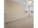Beige bedroom with neutral carpet, ceiling fan, and double windows overlooking a verdant yard at 210 Strolling Way, Durham, NC 27707