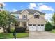 Charming two-story home featuring a well-manicured lawn, inviting porch, and a convenient two-car garage at 210 Strolling Way, Durham, NC 27707