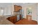 Well-lit kitchen features stainless steel appliances, granite countertops, and wood flooring at 210 Strolling Way, Durham, NC 27707