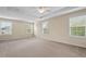 Large main bedroom with neutral carpeting, ceiling fan, and lots of natural light from windows at 210 Strolling Way, Durham, NC 27707