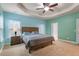 Bedroom with tray ceiling, ceiling fan, carpet, and a nightstand with a lamp at 2122 Aventon Ln, Morrisville, NC 27560