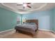 Spacious bedroom featuring a decorative tray ceiling, ceiling fan, and carpet flooring at 2122 Aventon Ln, Morrisville, NC 27560