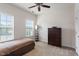A bright bedroom with two windows, a ceiling fan, a dresser, and carpeted floors at 2122 Aventon Ln, Morrisville, NC 27560