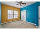 Colorful bedroom boasting yellow and blue walls and a ceiling fan for added comfort at 2122 Aventon Ln, Morrisville, NC 27560