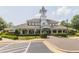 Exterior view of the community clubhouse, featuring a clock tower, parking, and landscaped grounds at 2122 Aventon Ln, Morrisville, NC 27560