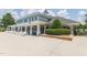 The community clubhouse exterior with a patio, tables, umbrellas, and well-maintained landscaping at 2122 Aventon Ln, Morrisville, NC 27560