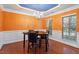 Elegant dining room features a stylish chandelier, vibrant orange walls, and classic wainscoting detail at 2122 Aventon Ln, Morrisville, NC 27560
