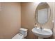 Cozy half bathroom with pedestal sink, round mirror, and neutral wall color at 2122 Aventon Ln, Morrisville, NC 27560