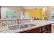 Close-up of granite countertop with stainless steel sink and faucet in a well-lit kitchen area at 2122 Aventon Ln, Morrisville, NC 27560