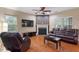 Cozy living room features a fireplace, hardwood floors, and a ceiling fan at 2122 Aventon Ln, Morrisville, NC 27560