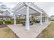 Outdoor picnic area with multiple picnic tables under a large white pergola and lush landscaping at 2122 Aventon Ln, Morrisville, NC 27560