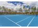 Bright blue community tennis court surrounded by trees, offering residents a recreational amenity at 2122 Aventon Ln, Morrisville, NC 27560