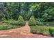 A brick path leads to a serene backyard garden with manicured bushes and lush greenery at 2204 Basil Drive, Raleigh, NC 27612