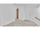 Carpeted basement area with white walls and trim, leading to a finished room with storage cabinets at 2204 Basil Drive, Raleigh, NC 27612
