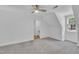 Spacious carpeted bedroom with natural light from the double-hung windows and a modern ceiling fan at 2204 Basil Drive, Raleigh, NC 27612