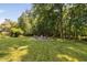 Serene backyard with a fire pit area surrounded by mature trees and lush greenery, ideal for relaxation at 228 Grantwood Dr, Holly Springs, NC 27540