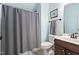 Bathroom with a gray shower curtain, wooden cabinet, white toilet, and neutral decor at 228 Grantwood Dr, Holly Springs, NC 27540