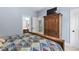Cozy bedroom features an armoire, bathroom, and light blue painted walls, offering a peaceful retreat at 228 Grantwood Dr, Holly Springs, NC 27540