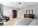 Cozy bedroom showing the bed with grey blanket, wooden dresser and night stand, and leather chair at 228 Grantwood Dr, Holly Springs, NC 27540
