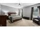 Spacious bedroom boasts a ceiling fan, a large window, and an elegant wooden bed frame with matching furniture at 228 Grantwood Dr, Holly Springs, NC 27540