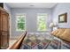 Bright bedroom with dual windows, wooden bed frame and a cozy quilt, creating a peaceful and inviting space at 228 Grantwood Dr, Holly Springs, NC 27540