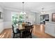 Bright dining area featuring a large table, hardwood floors, and stylish decor at 228 Grantwood Dr, Holly Springs, NC 27540