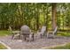 Outdoor fire pit with Adirondack chairs surrounded by mature trees, perfect for entertaining at 228 Grantwood Dr, Holly Springs, NC 27540