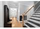 Inviting hallway with hardwood floors, staircase and a coat rack for a modern and stylish look at 228 Grantwood Dr, Holly Springs, NC 27540