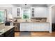 Bright kitchen featuring white cabinets, granite countertops, stainless steel appliances and hardwood floors at 228 Grantwood Dr, Holly Springs, NC 27540