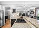 Kitchen view showcasing granite countertops and a gas stovetop, flowing seamlessly into the living space at 228 Grantwood Dr, Holly Springs, NC 27540