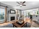 Inviting living room featuring a fireplace, hardwood floors, and a glimpse of the kitchen area at 228 Grantwood Dr, Holly Springs, NC 27540