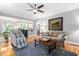 Inviting living room featuring hardwood floors, modern ceiling fan, and seamless flow to the kitchen at 228 Grantwood Dr, Holly Springs, NC 27540