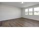 Clean, empty bedroom with hardwood floors and plenty of natural light from multiple windows at 267 Old Fashioned Way, Lillington, NC 27546