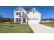 Charming two-story home with white siding, a well-manicured lawn, and an attached two-car garage at 267 Old Fashioned Way, Lillington, NC 27546
