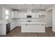 Bright kitchen with white cabinets, stainless steel appliances, a large island, and modern pendant lighting at 267 Old Fashioned Way, Lillington, NC 27546