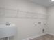 Functional laundry room with utility sink and shelving units at 267 Old Fashioned Way, Lillington, NC 27546