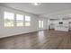 Open living area with lots of natural light, hardwood floors, and a view into the kitchen at 267 Old Fashioned Way, Lillington, NC 27546