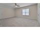 Spacious bedroom with plush carpeting, a ceiling fan, and natural light from a large window at 3020 High Plains Dr, Fuquay Varina, NC 27526