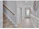 Inviting hallway featuring hardwood floors, a staircase, modern lighting, and white wainscoting at 3020 High Plains Dr, Fuquay Varina, NC 27526