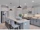 Modern eat-in kitchen with stainless steel appliances, gray cabinets, and a large center island at 3020 High Plains Dr, Fuquay Varina, NC 27526