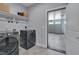 Gray laundry machines, a storage shelf, and a door leading to the garage at 3020 High Plains Dr, Fuquay Varina, NC 27526