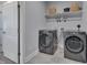 Laundry room with gray washer and dryer, upper storage shelf, and tile flooring at 3020 High Plains Dr, Fuquay Varina, NC 27526