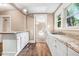 Bright kitchen featuring white cabinetry, granite countertops, and stainless steel sink with views of the backyard at 306 Union Ave, Burlington, NC 27217