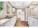 Well-lit kitchen featuring white cabinets, stone countertops, and modern appliances at 306 Union Ave, Burlington, NC 27217