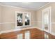 Sunlit living room featuring hardwood floors, fresh paint, and oversized windows at 306 Union Ave, Burlington, NC 27217